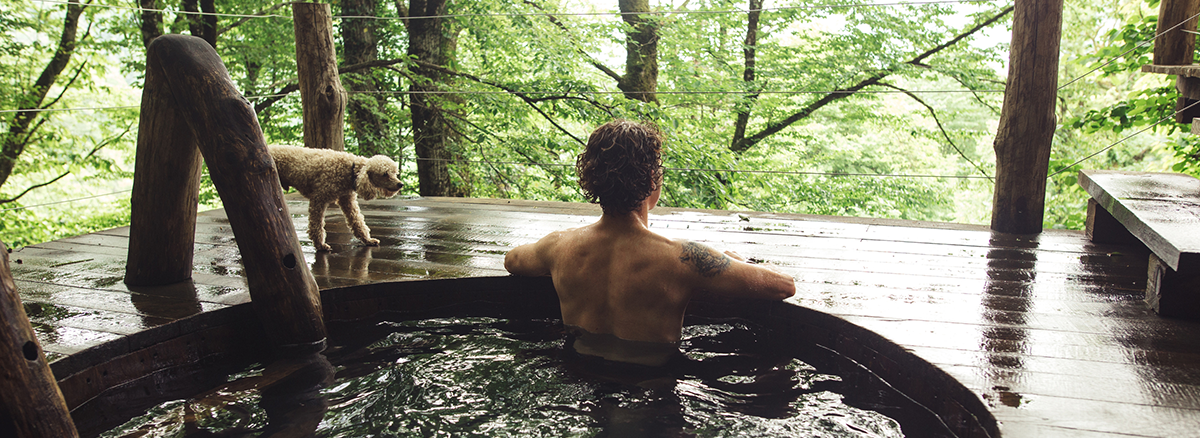 A slow, restorative moment in nature: forest bathing or a thermal bath, the body gently engaged